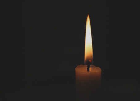 Single candle with lit flame